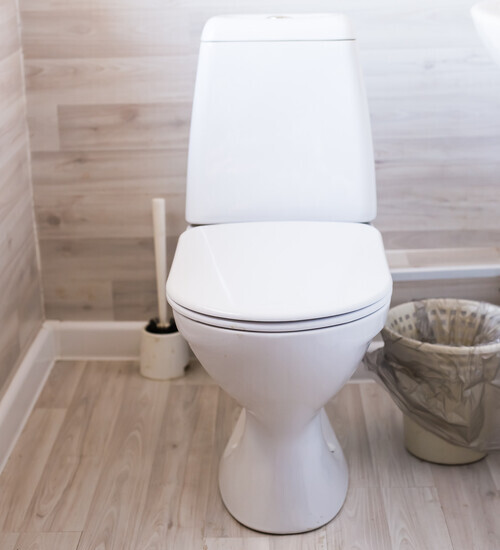 toilet sitting in a wooden bathroom